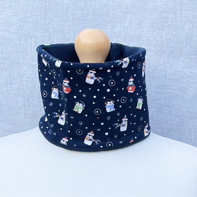 Penguin jersey neck warmer lined with organic cotton fleece. Penguins in hats and scarves and wearing headphones